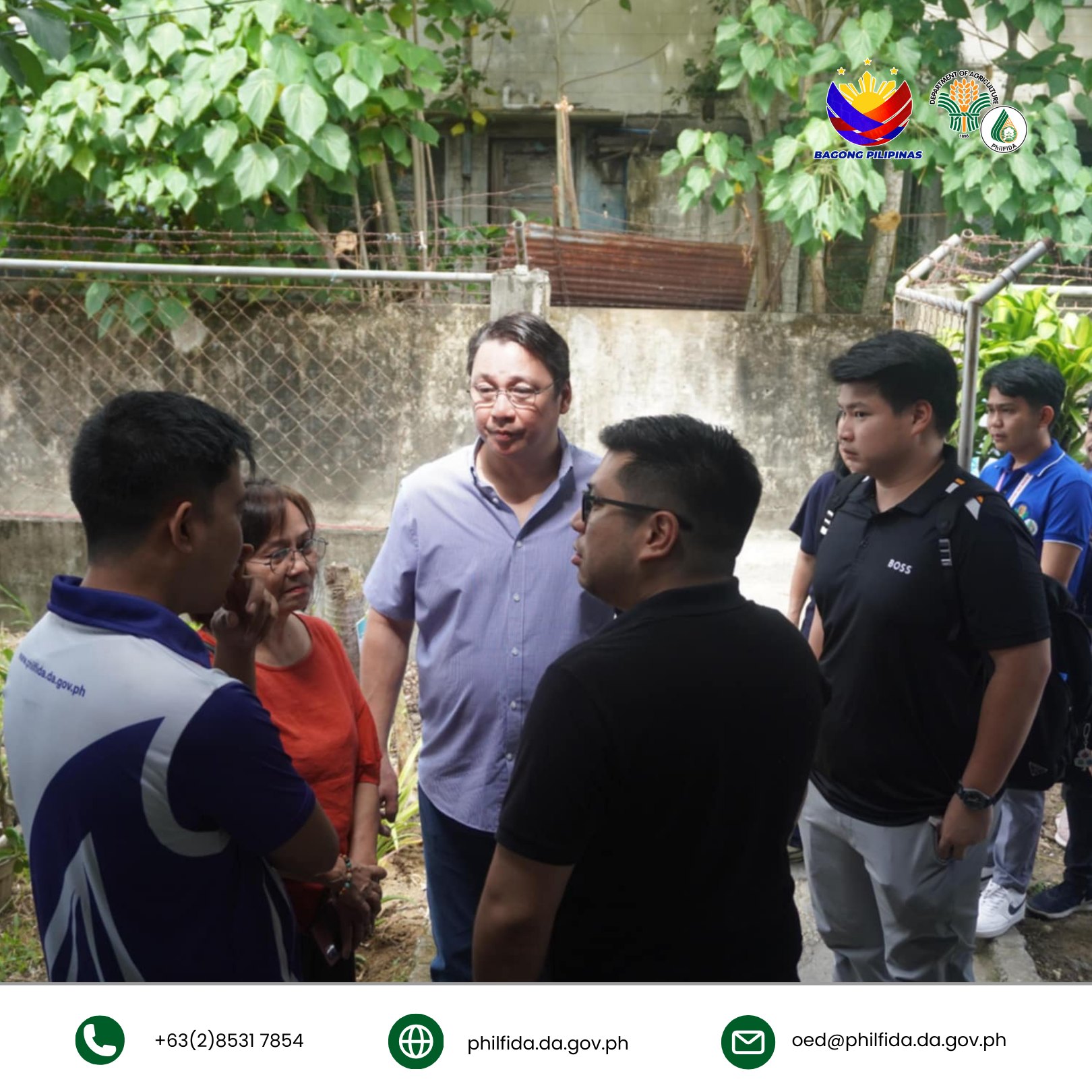 A man engaged in conversation with a group of people, actively communicating and interacting.