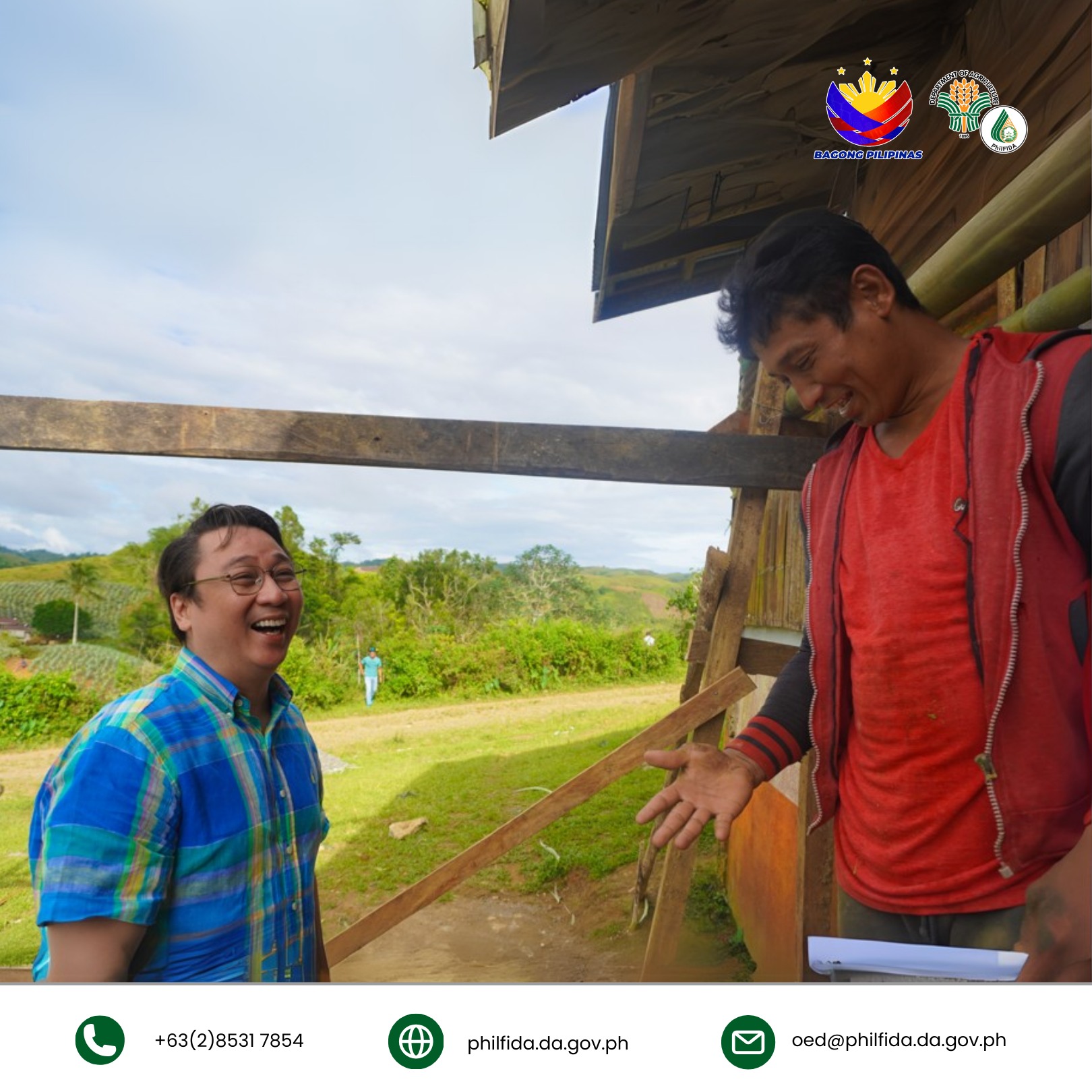 A smiling man happily chatting with a friend in a casual, warm setting.