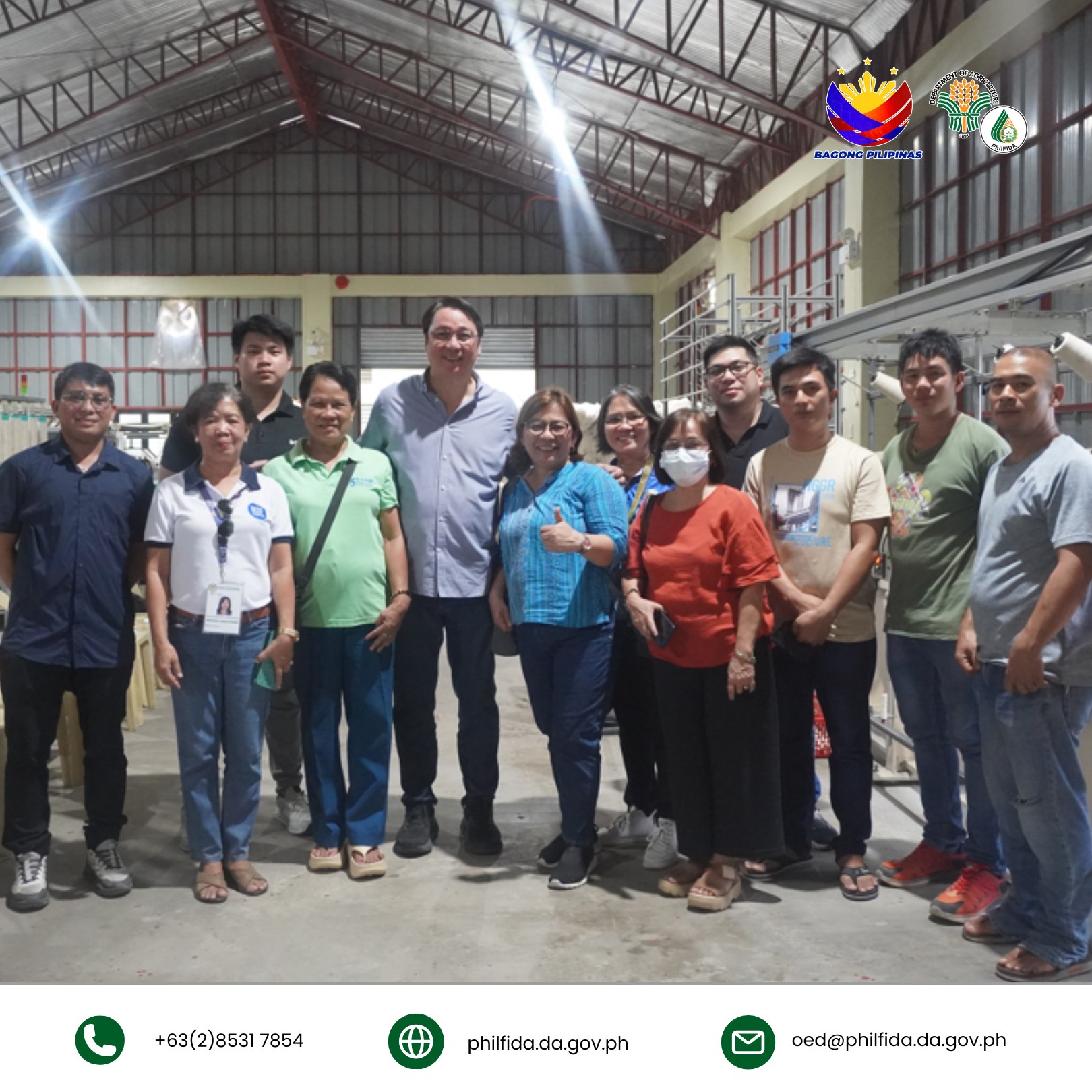 A group picture of people inside a cotton processing center.