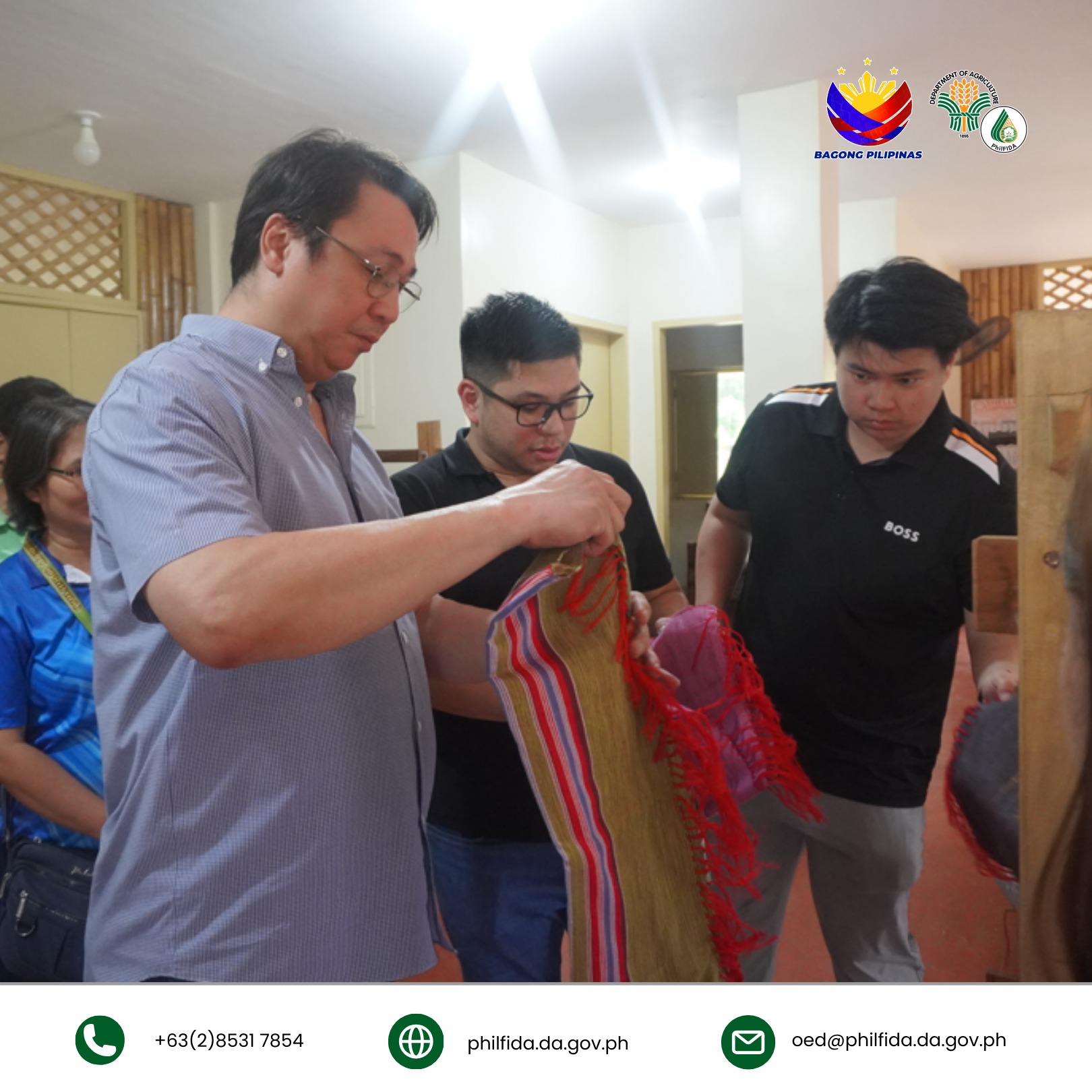 A group of men inspecting a piece of cotton-woven cloth.